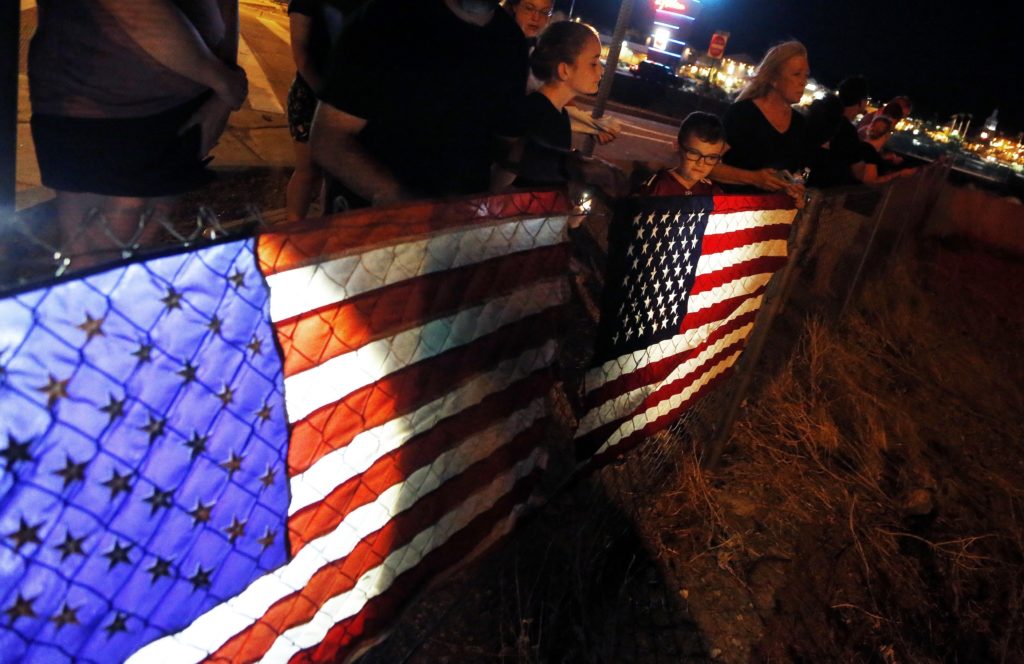 Photo of citizens lining street at night to honor John McCain