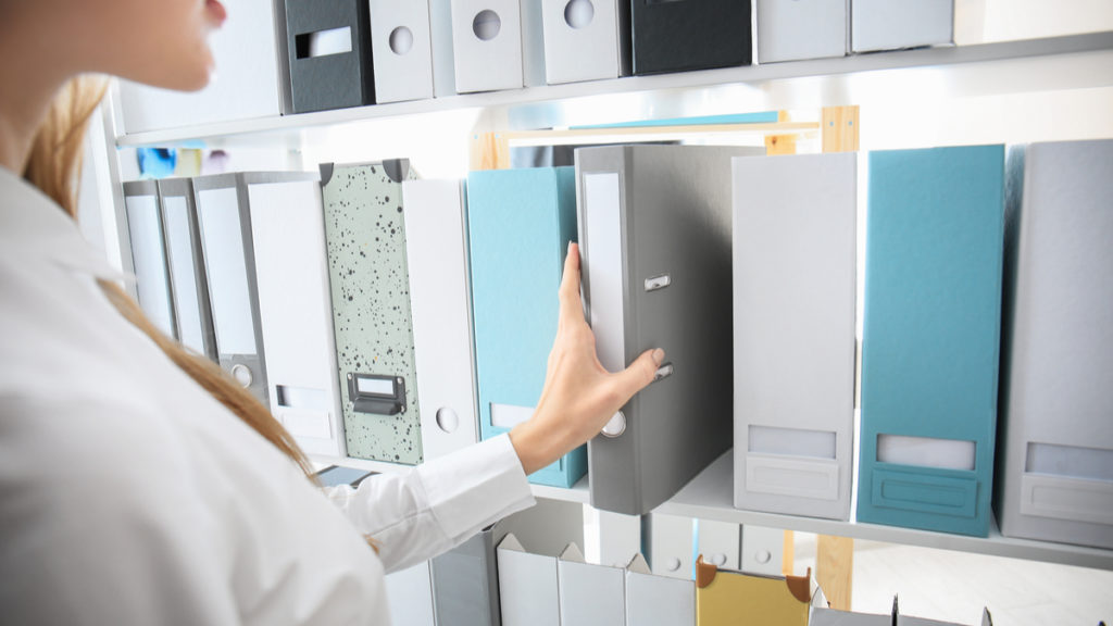 Photo of a woman pulling budget binders from a shelf