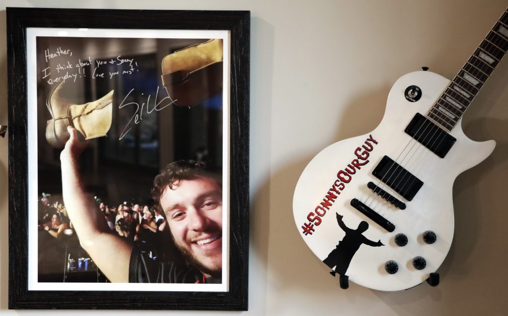 Photo of a picture of Sonny Melton, autographed by Eric Church, and a guitar from the Eric Church fan club