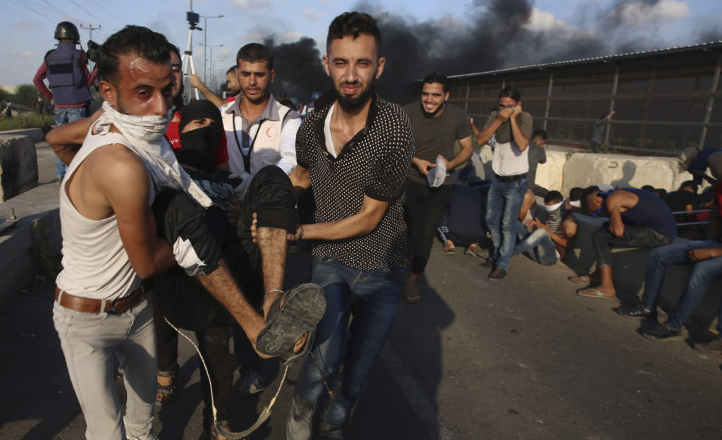 Photo of medic evacuating wounded youth during protest in Gaza