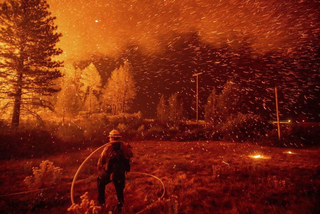 Photo of embers flying around a firefighter