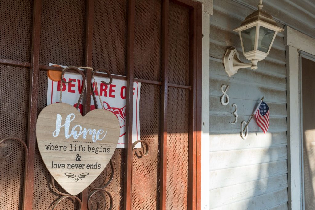 Photo of two signs on the door of a house in Redlands, CA.