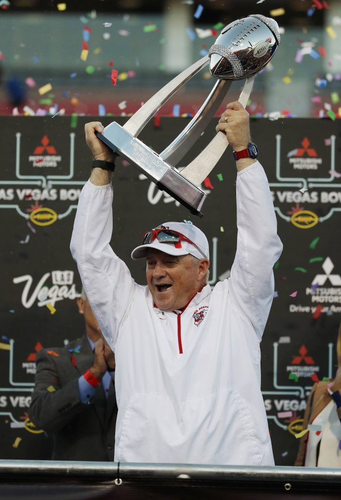Photo of Fresno State football coach Jeff Tedford holding the trophy