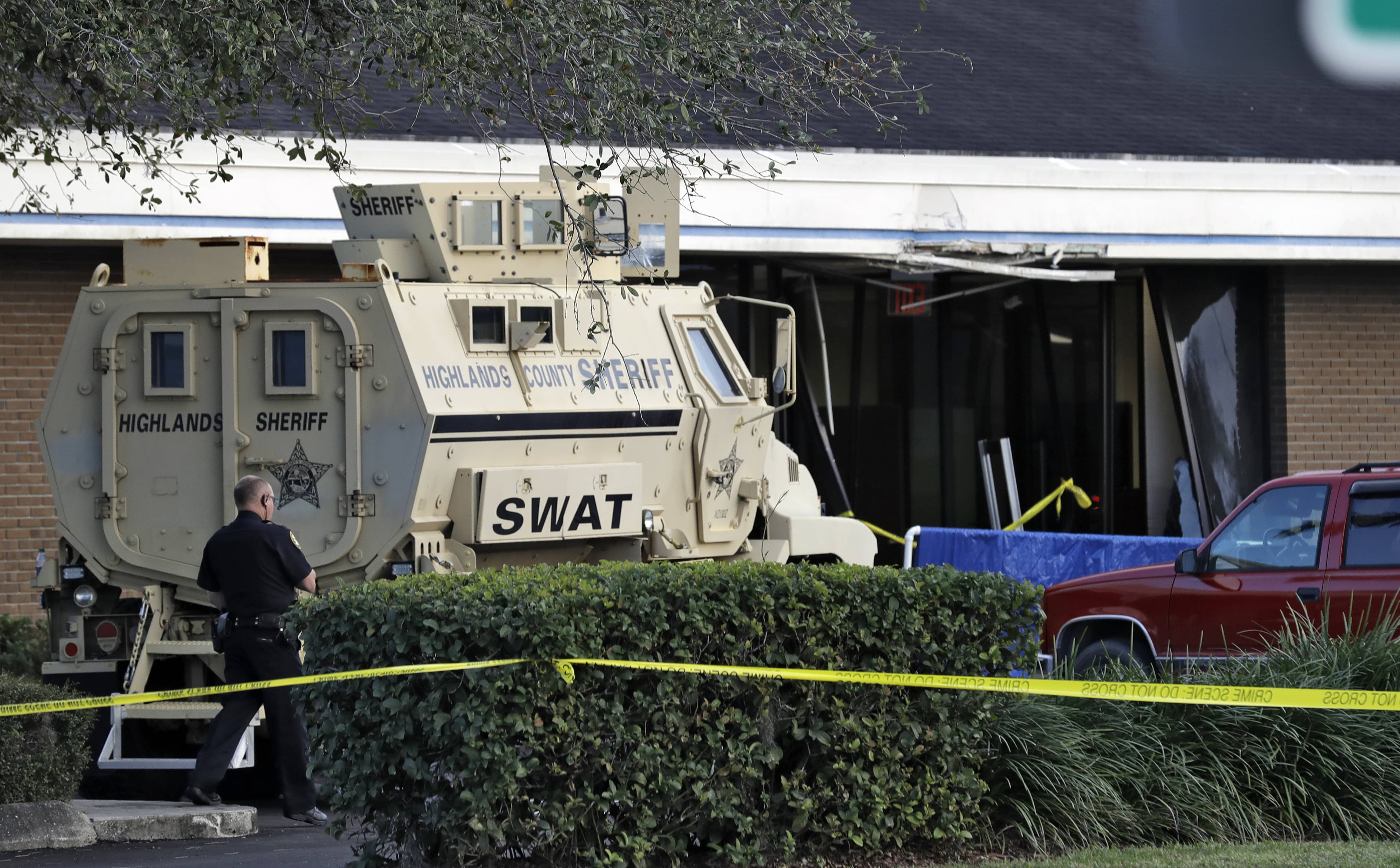 A photo of police officer standing near a Highlands County Sheriff's SWAT vehicle