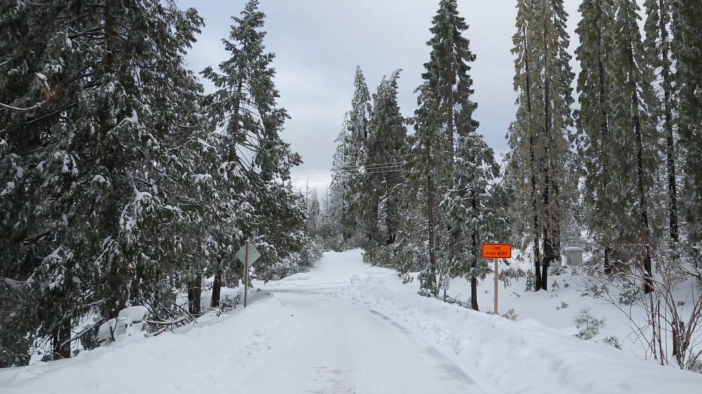 A photo of snow covering the road into Shaver Lake