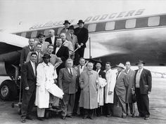 Photo of officials and employees of the Brooklyn Dodgers posed in front of the club's plane in New York City before leaving for Los Angeles