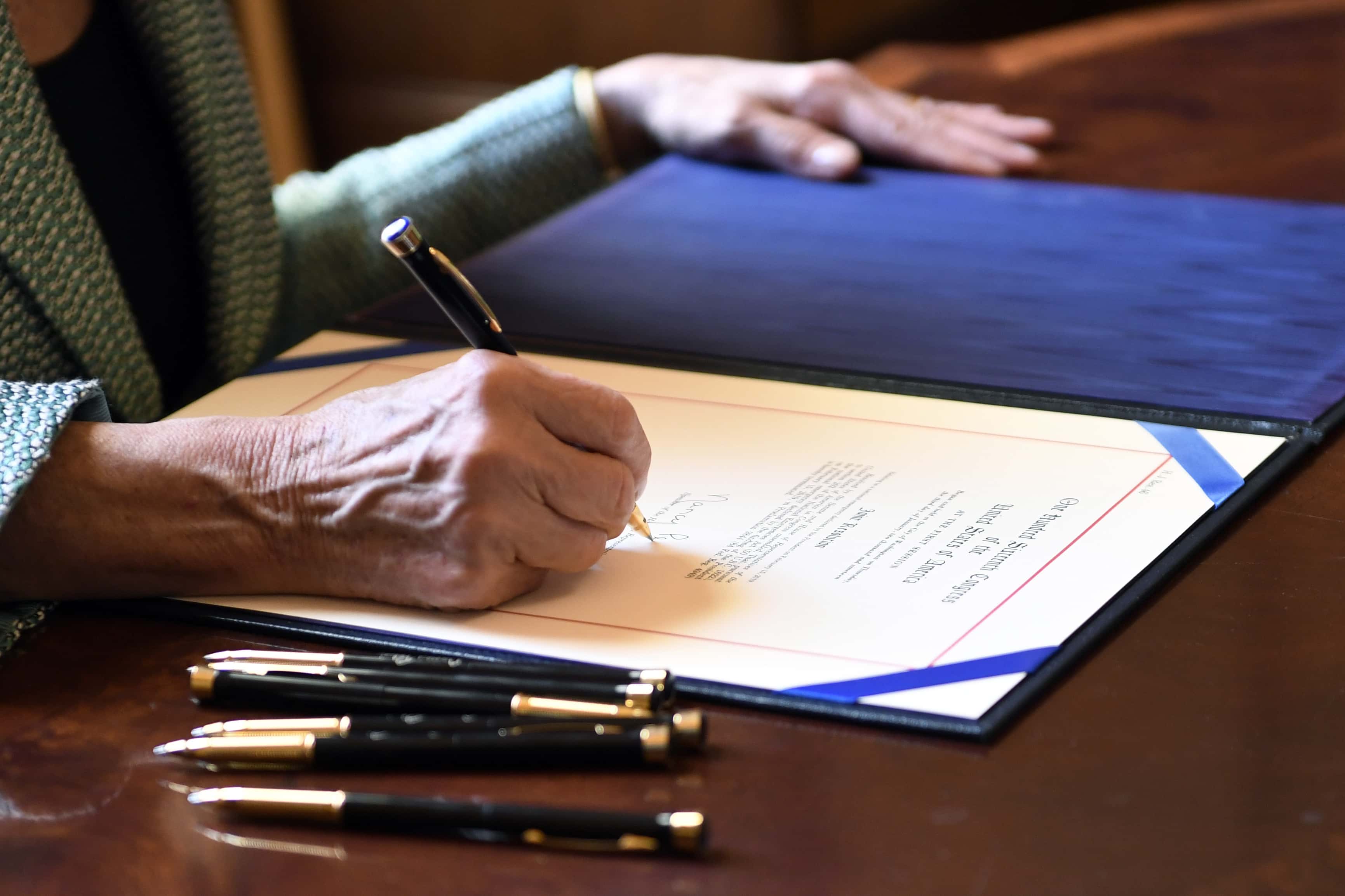 Photo of Nancy Pelosi signing H.J. Res 46