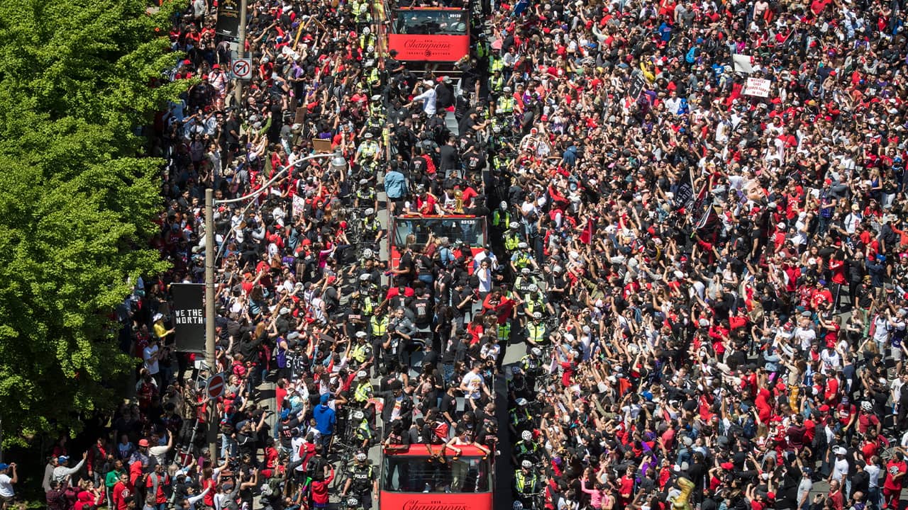 Photo of members of the Toronto Raptors riding on buses during a victory parade in Toronto