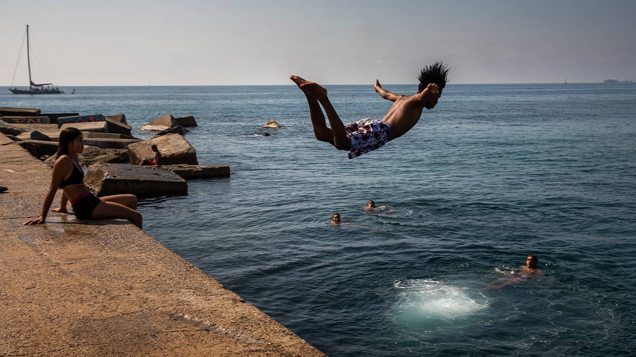 Photo of a boy jumping into the water in Spain