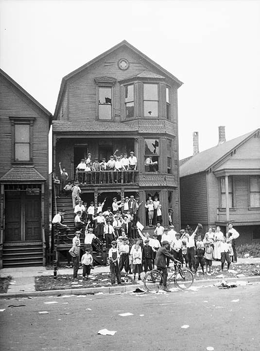 Photo of a crowd gathered at a house that has been vandalized and looted during the race riots in Chicago