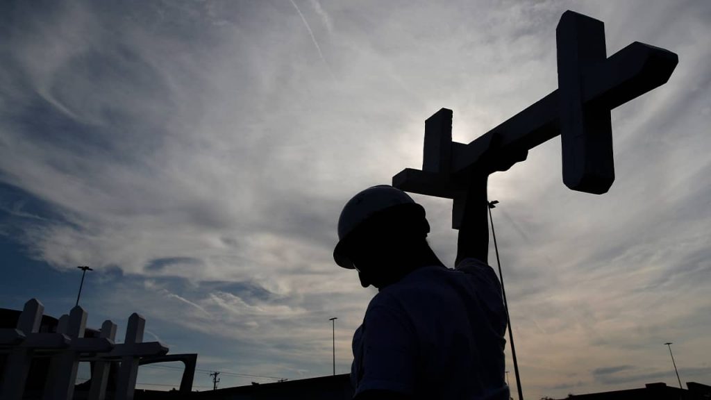 Photo of a man carrying a cross in El Paso, Texas