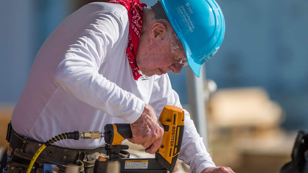 Photo of former President Jimmy Carter working with volunteers on site