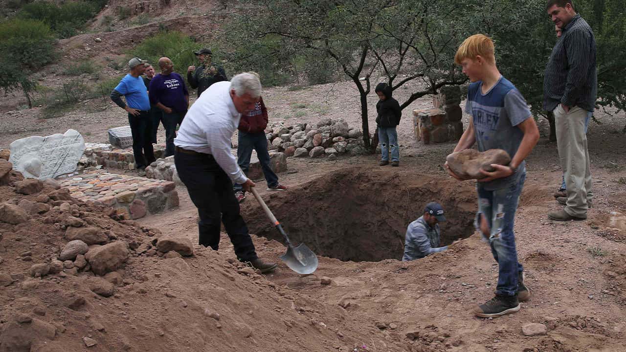 Photo of men digging a grave