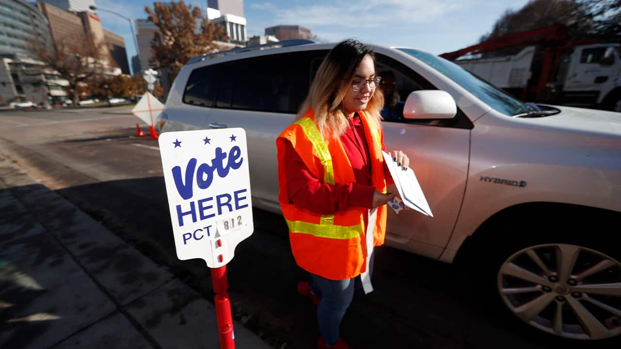 Photo of an election judge collecting a ballot