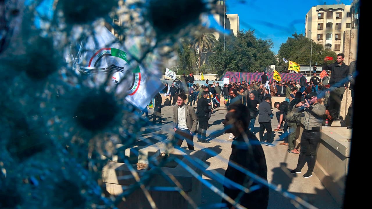 Photo of protestors seen through a broken window