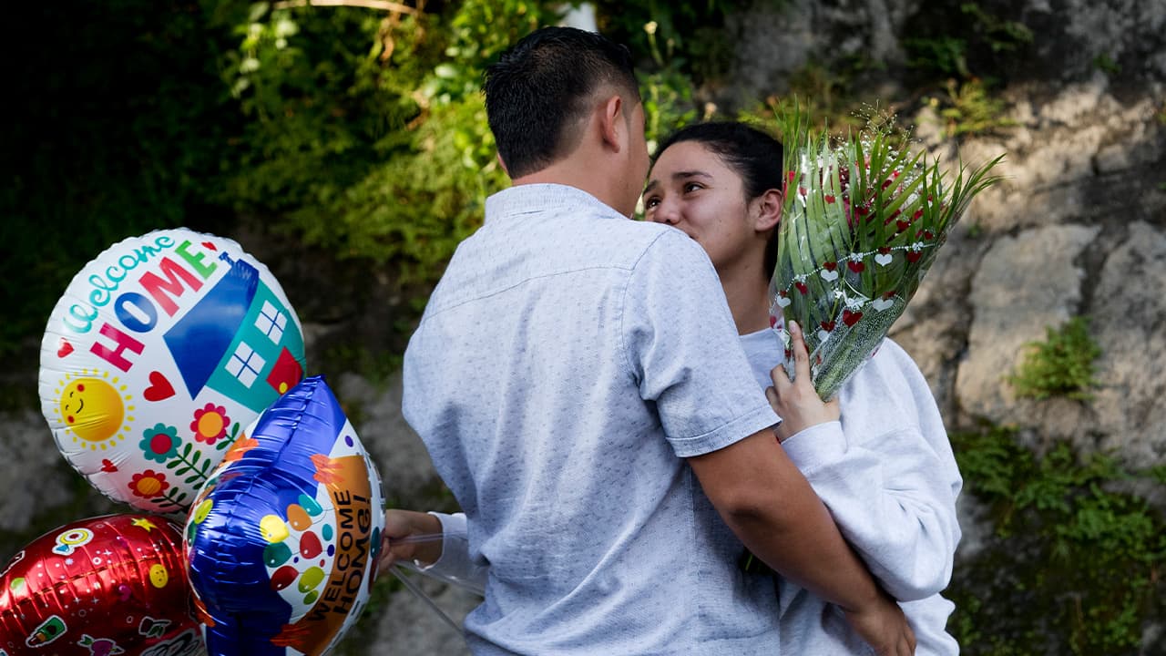 Photo of 2 people outside the Migrant Assistance Office in El Salvador