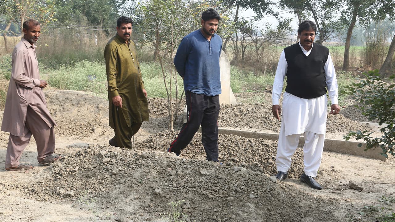 Photo of Samiya David's family visiting her unmarked grave in Pakistan