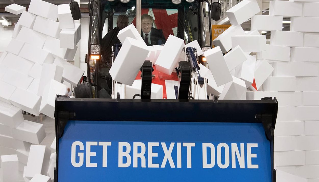 Photo of Boris Johnson sitting in the cab breaking through a symbolic wall