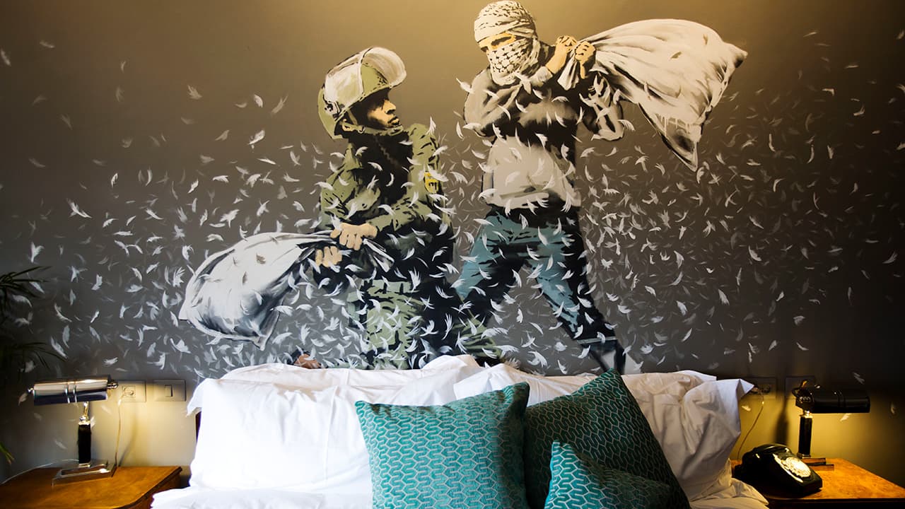 Photo of a Banksy wall painting showing an Israeli border police officer and a Palestinian in a pillow fight