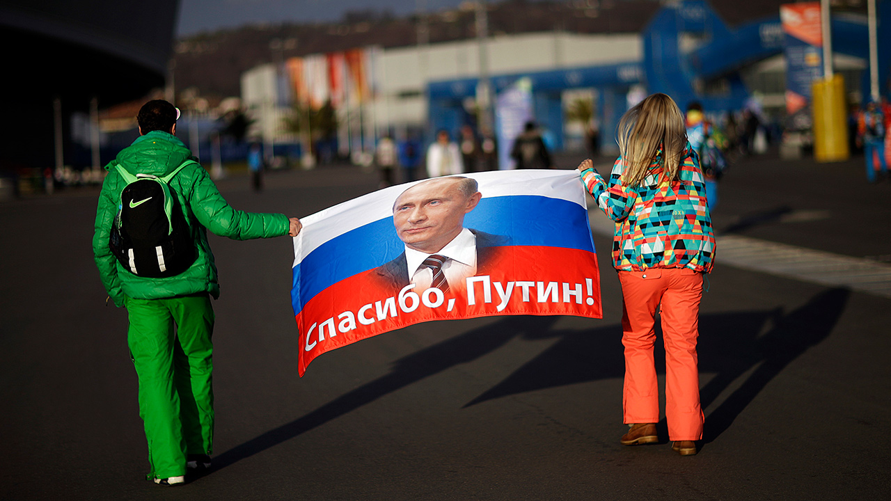 Photo of Veleriya Obarevich, right, and Yan Shamilov carrying a Russian flag