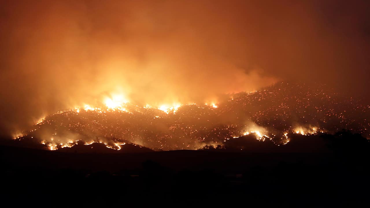 Photo of a wildfire threatening property glows on the hills near Clear Range, south of the Australian capital, Canberra