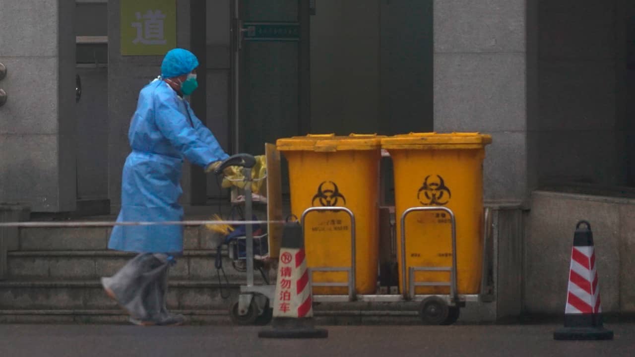 Photo of staff members moving bio-waste containers in China