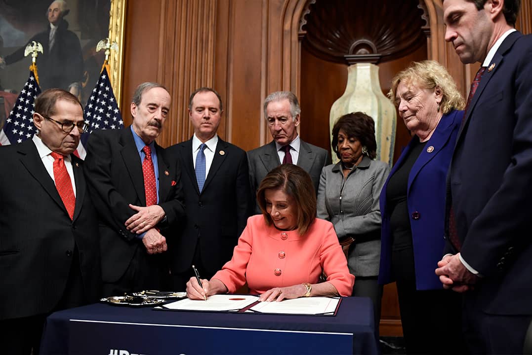 Photo of Nancy Pelosi signing the resolution to transmit the articles of impeachment