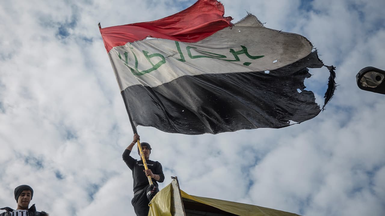 Photo of protesters flying an Iraqi flag