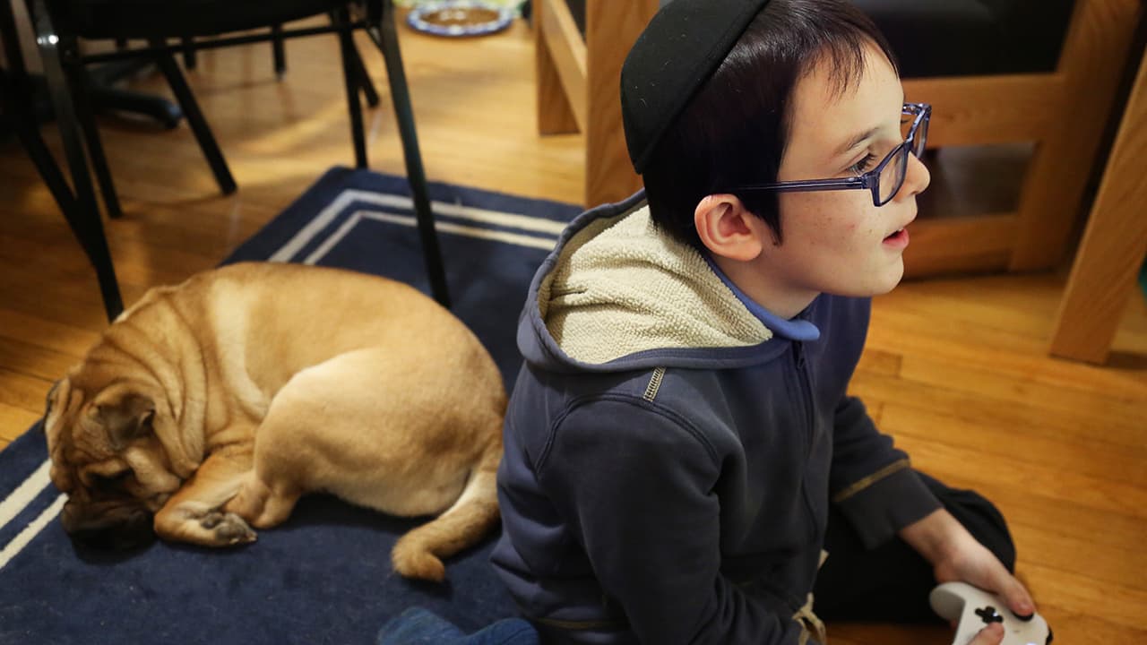 Photo of Gavriel Menachem Blum, 10, playing a video game before Shabbat dinner