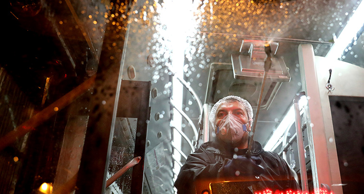 Photo of a worker disinfecting a public bus in Tehran, Iran
