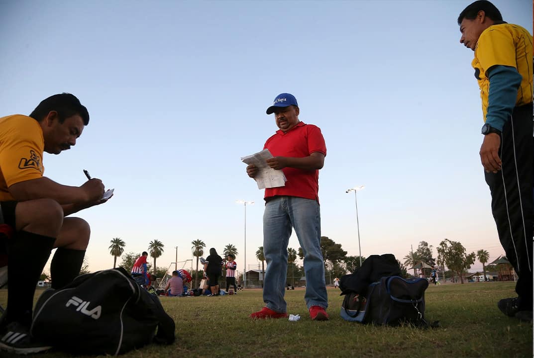 Photo of Antonio Velasquez, center, a pastor and director of the Maya Chapin soccer league