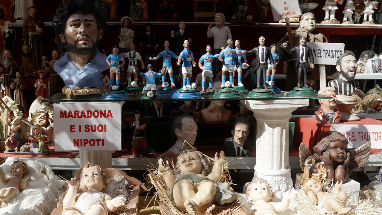 Photo of a placard reading Maradona and his nephew displayed in a shop with the statuettes of soccer legend and former Napoli player Diego Armando Maradona together with nativity scenes ones