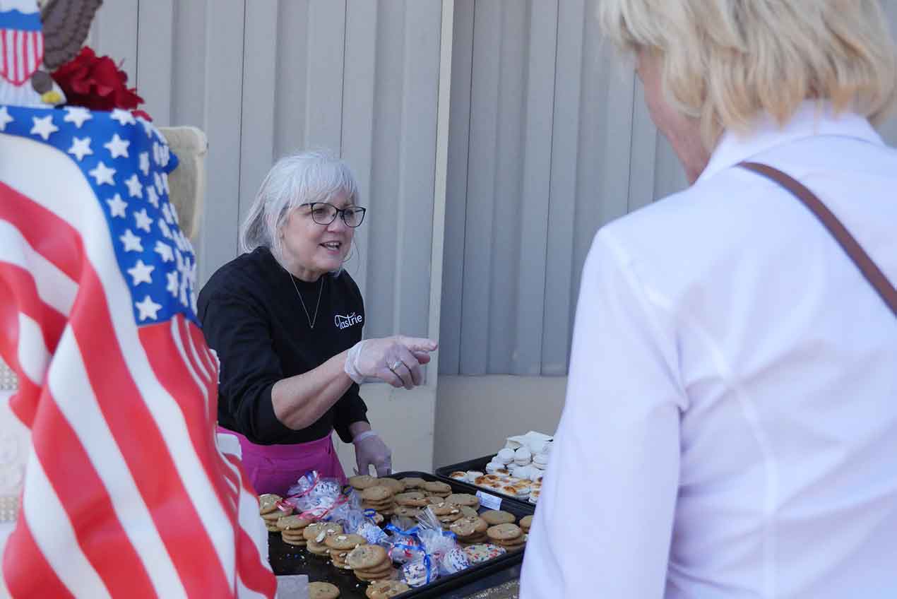 Photo of Tastries Bakery owner Cathy Miller handing out cookies in Bakersfield, Californiaent