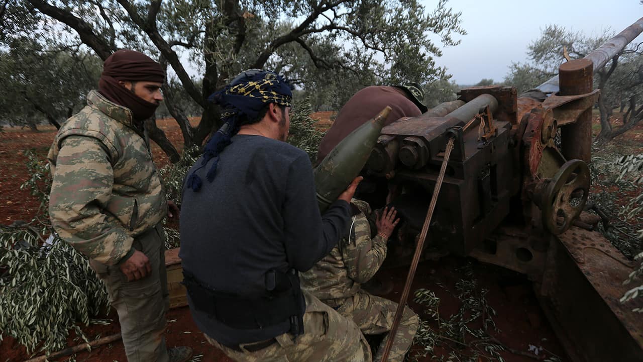 Photo of Syrian rebel fighters preparing to shoot a howitzer