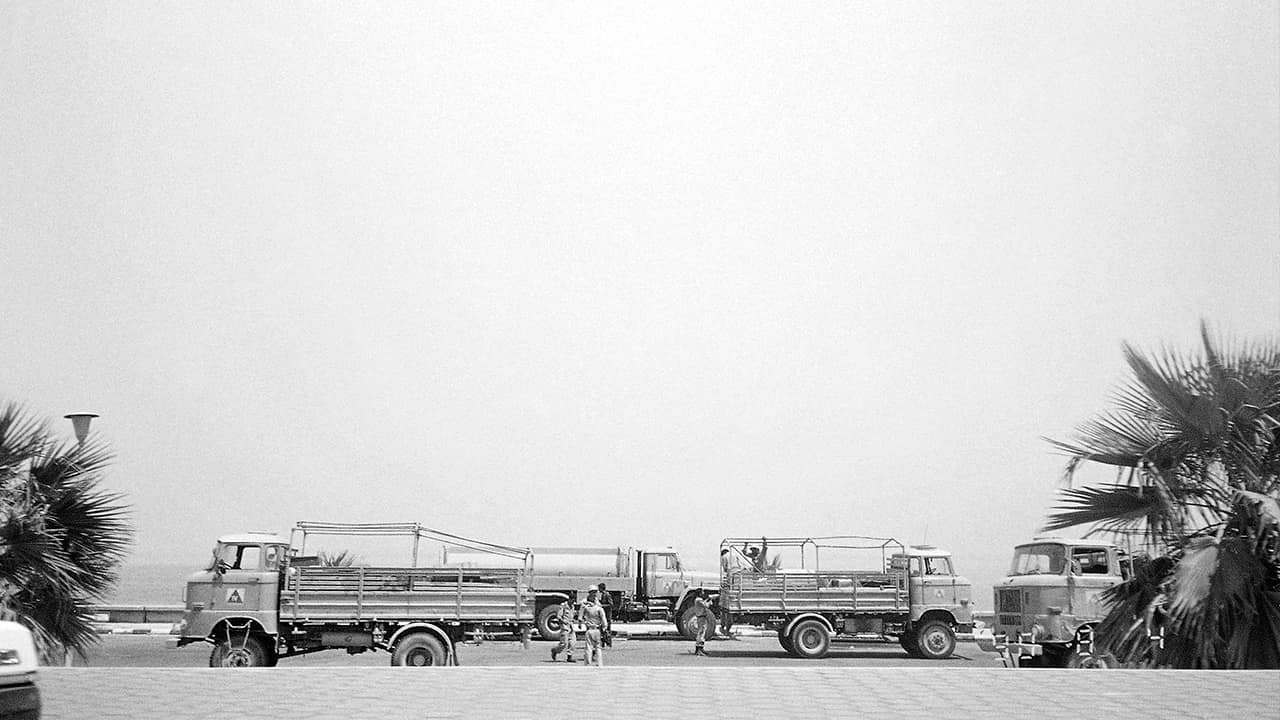 Photo of Iraqi soldiers getting off the back of a troop carrier along the beachfront area in Kuwait City in 1990