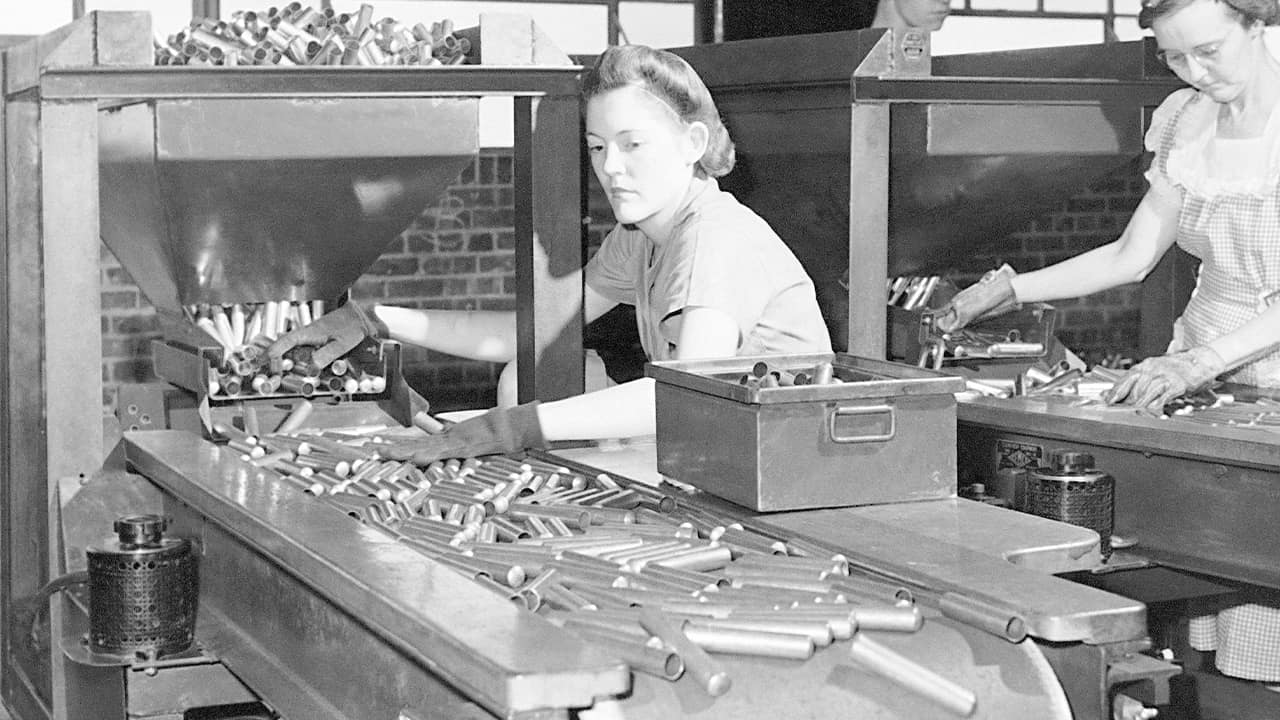 Photo of factory workers inspecting shell casings in 1942