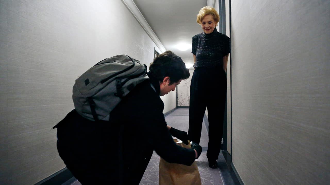 Photo of Liam Elkind delivering groceries to Carol Sterling