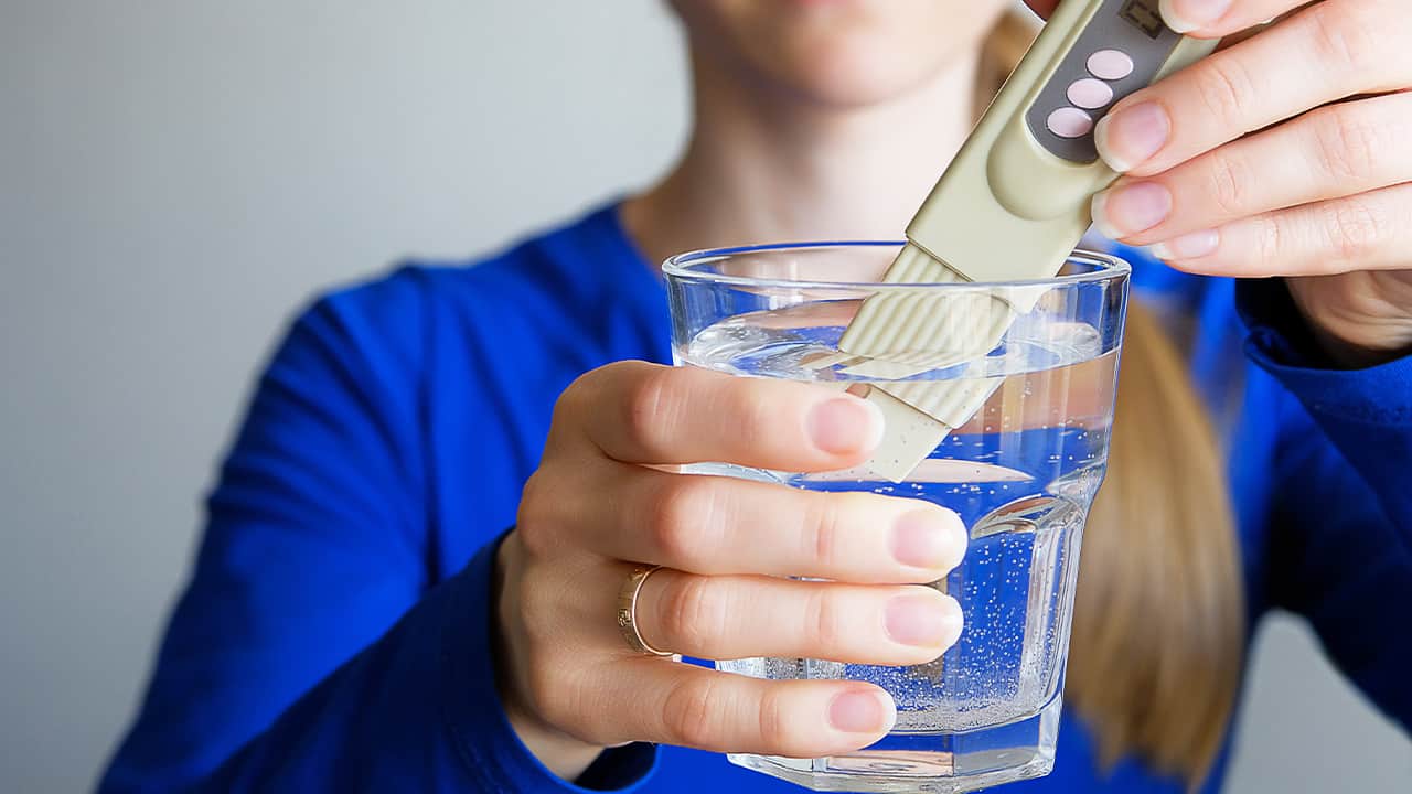 Photo of a young woman testing the safety of tap drinking water