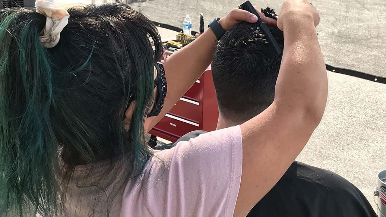 Image of a hair stylist working outdoors so the shop can stay open during COVID-19p o